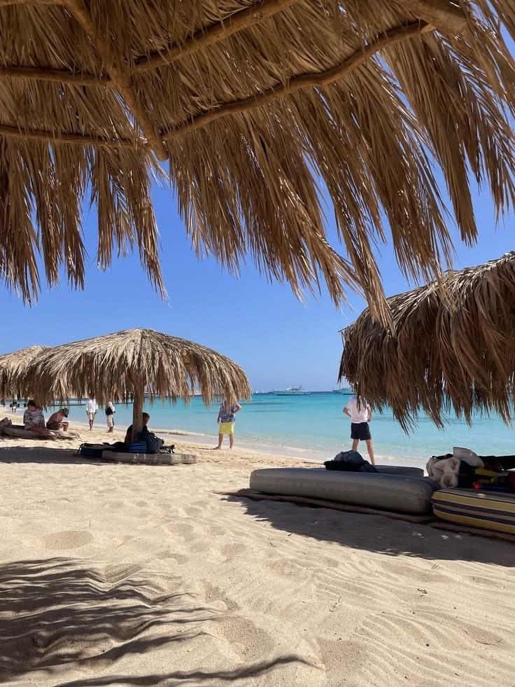 Straw parasols framing the turquoise sea at Hula Hula Island