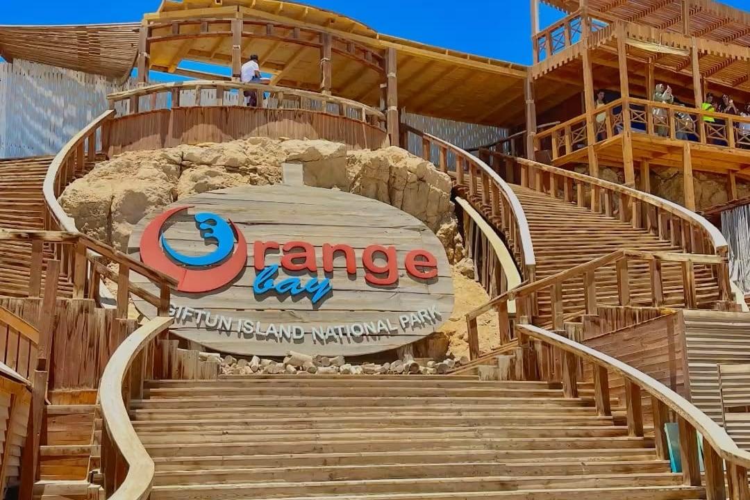 Orange Bay sign at the top of the wooden steps leading down to the beach